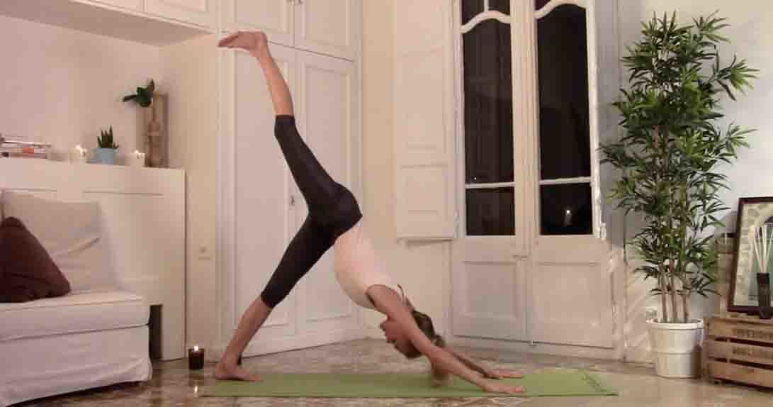 Actress doing yoga downward dog with raised leg