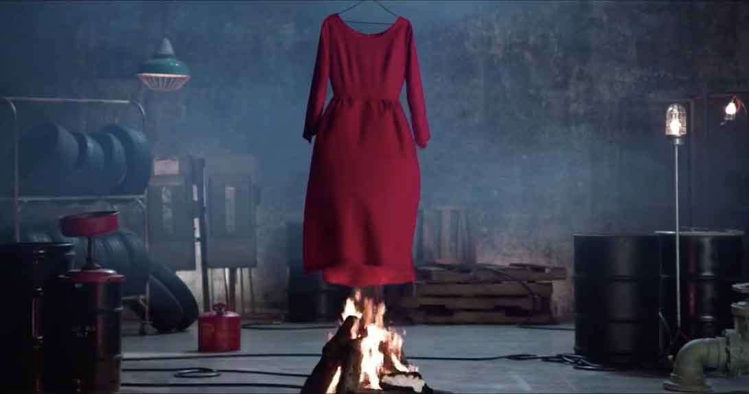 Burning Handmaid's red dress over bonfire