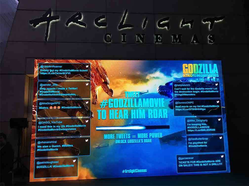 Godzilla jumbo screen displaying tweets from users